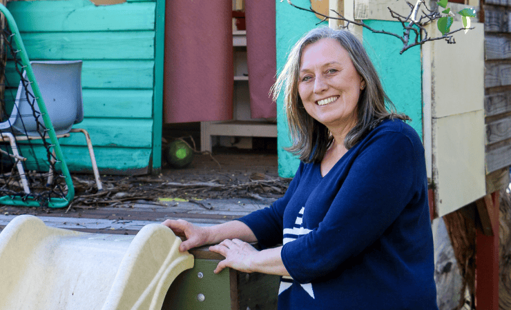 Elly pictured outdoors near a childrens play house