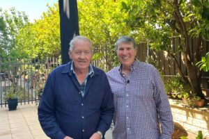 Older man standing with elderly aged care resident