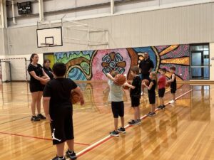 kids listening to basketball teacher