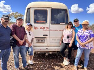 A group of adults standing in front of a shuttle bus