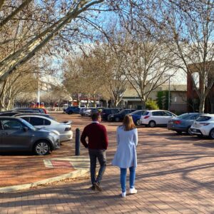 A man and a woman walking together in a car park