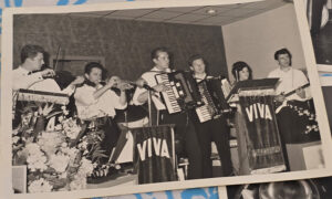 Image of an old black and white photograph showing 6 piece band on stage