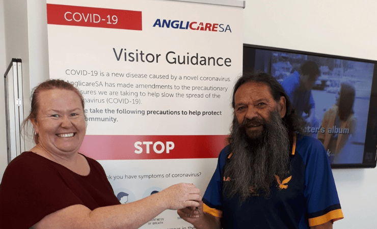 AnglicareSA tenancy officer Jamie handing the keys over to Uncle Cecil.