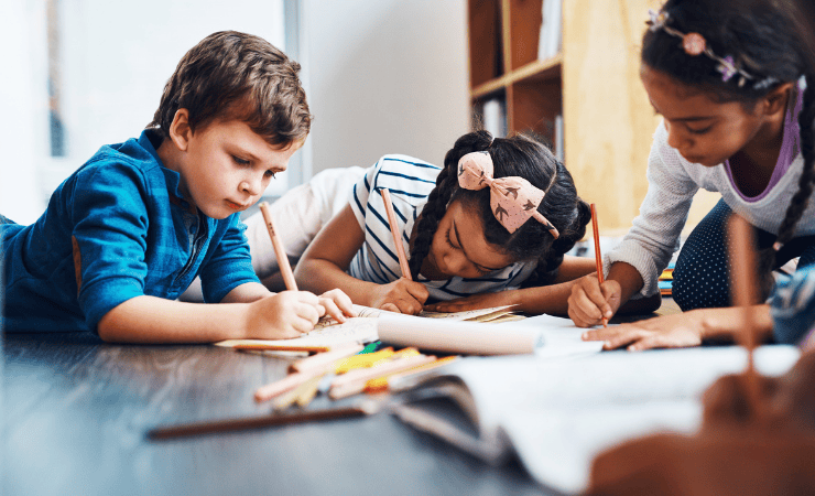 Three kids drawing on the floor