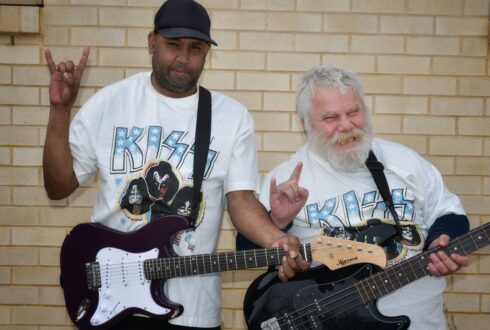 Adrian and Kingsley rocking on with their guitars and white KISS tshirts on