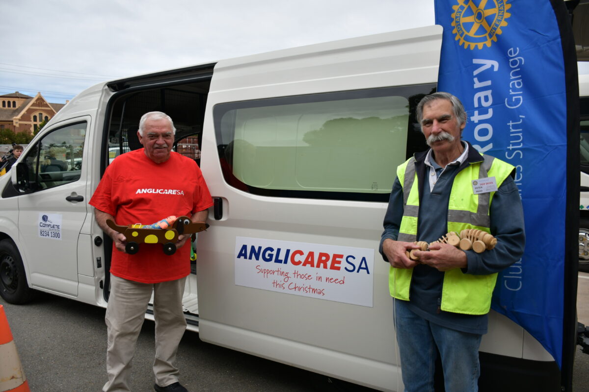 The Toy Boys stand with their creations in front of an AnglicareSA van.